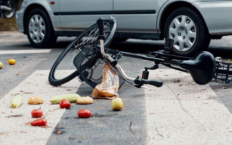 Broken bicycle on street after collision with a car